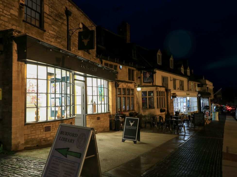 An outdoor view of Burford Library in Burford with tables and chairs outside