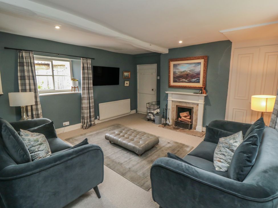 A living room with sofas and a fireplace at Black Horse Cottage in Swainby