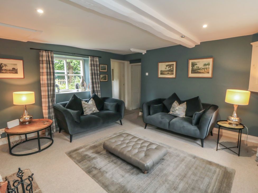 A living room with sofas and a rug at Black Horse Cottage in Swainby