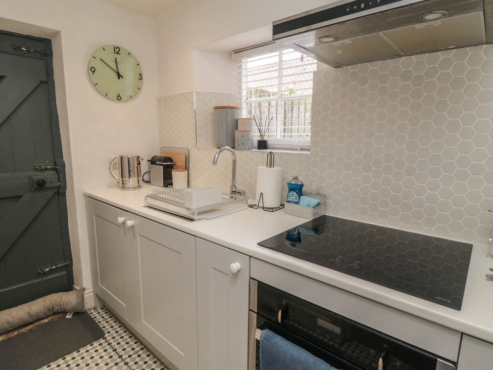 A kitchen with appliances and countertop at Black Horse Cottage in Swainby
