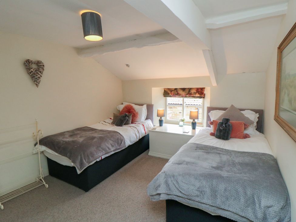 A bedroom with two beds and lamps at Black Horse Cottage in Swainby