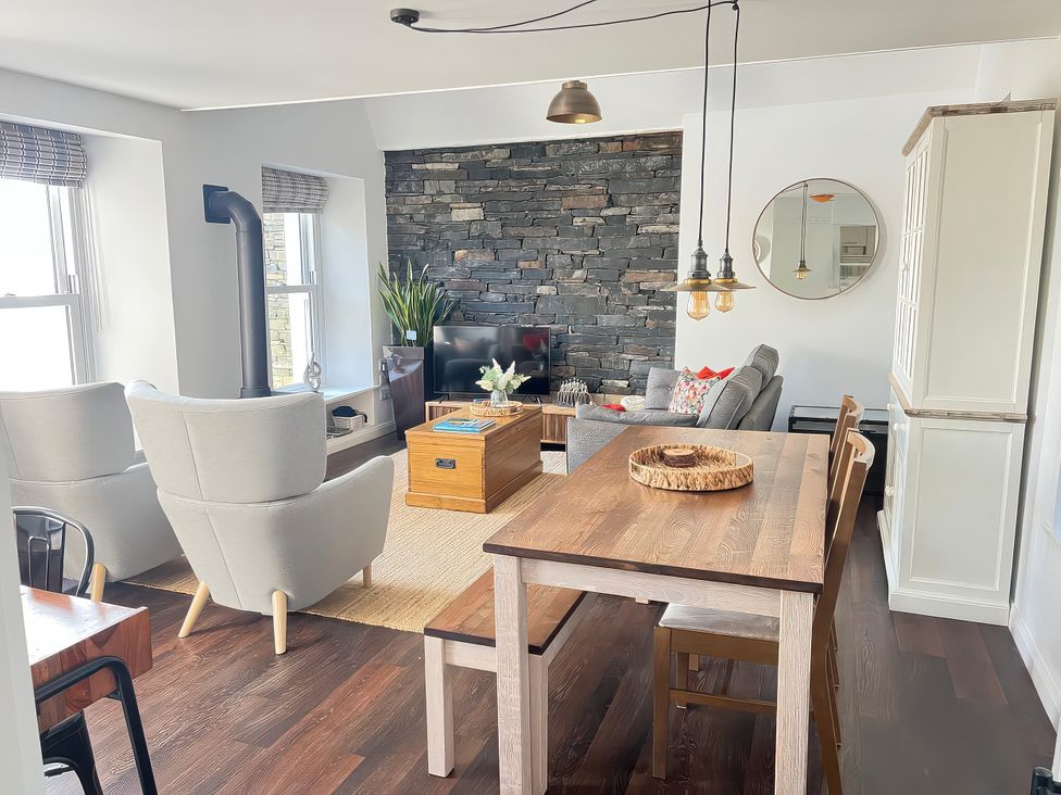 A living room with a sofa and dining table at Moorhurst Cottage in Kents Bank near Grange-Over-Sands