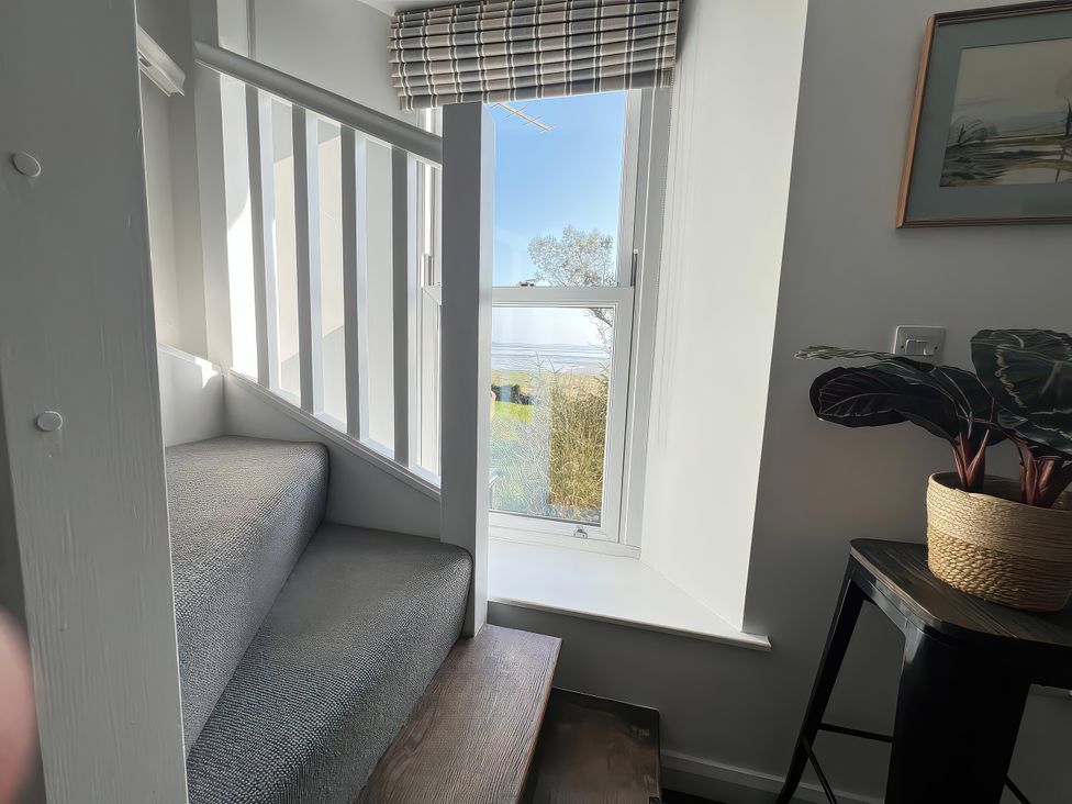 A staircase with a window and plant at Moorhurst Cottage in Kents Bank near Grange-Over-Sands