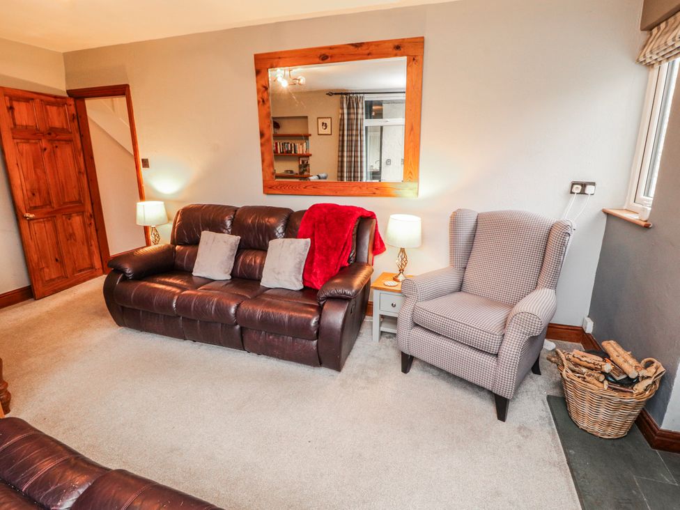 A living room with a sofa and armchair at Greenbank Cottage in Winster near Bowness-On-Windermere