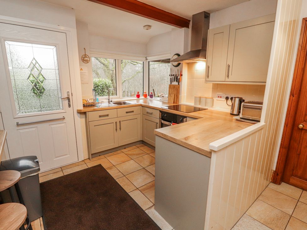 A kitchen with appliances and cabinets at Greenbank Cottage in Winster near Bowness-On-Windermere