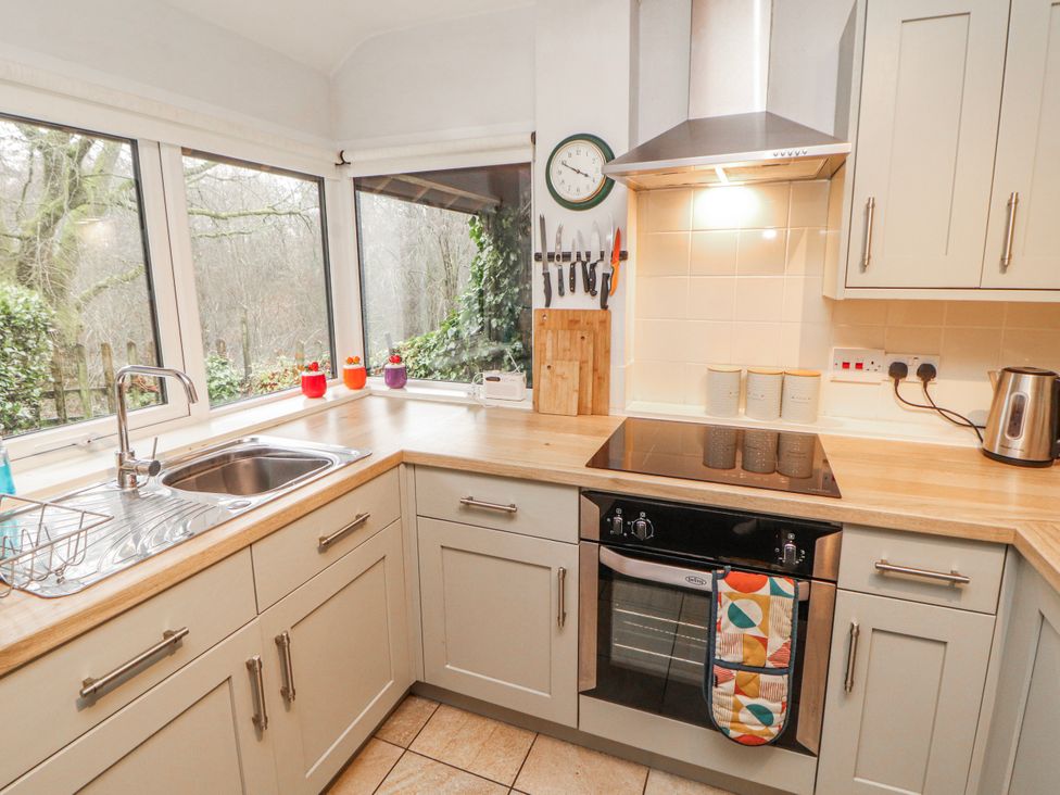 A kitchen with sink and stove at Greenbank Cottage in Winster near Bowness-On-Windermere