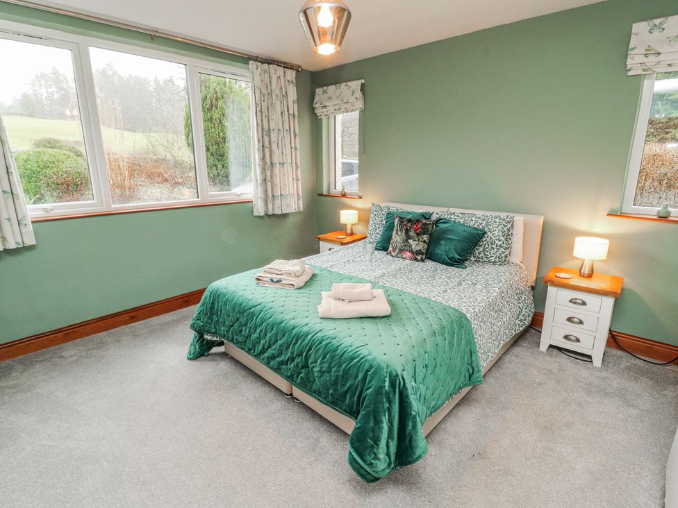 A bedroom with a bed and bedside tables at Greenbank Cottage Winster near Bowness-On-Windermere