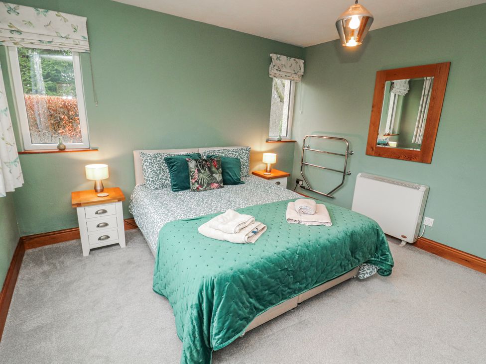 A bedroom with a bed and window at Greenbank Cottage in Winster near Bowness-On-Windermere