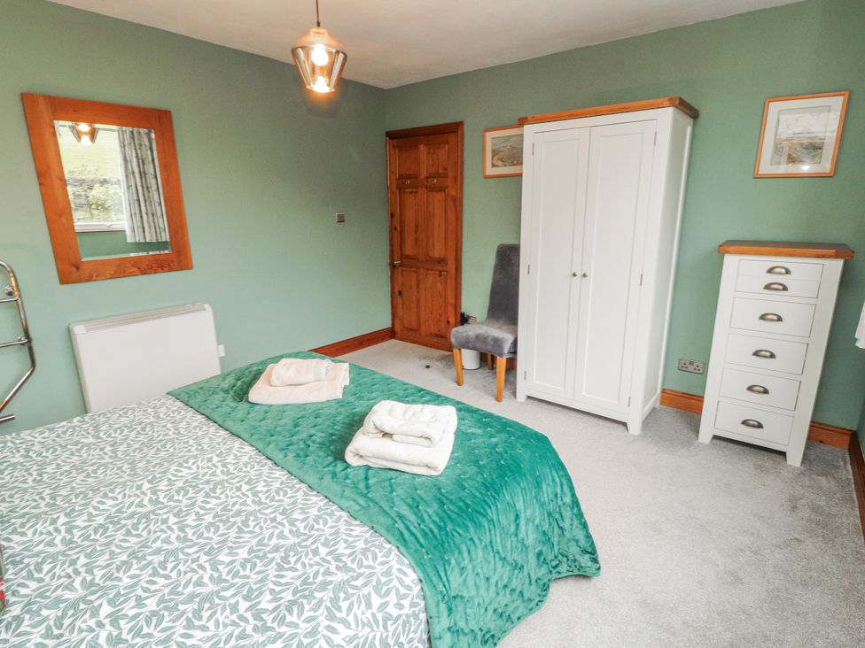 A bedroom with a bed and furniture at Greenbank Cottage Winster near Bowness-On-Windermere