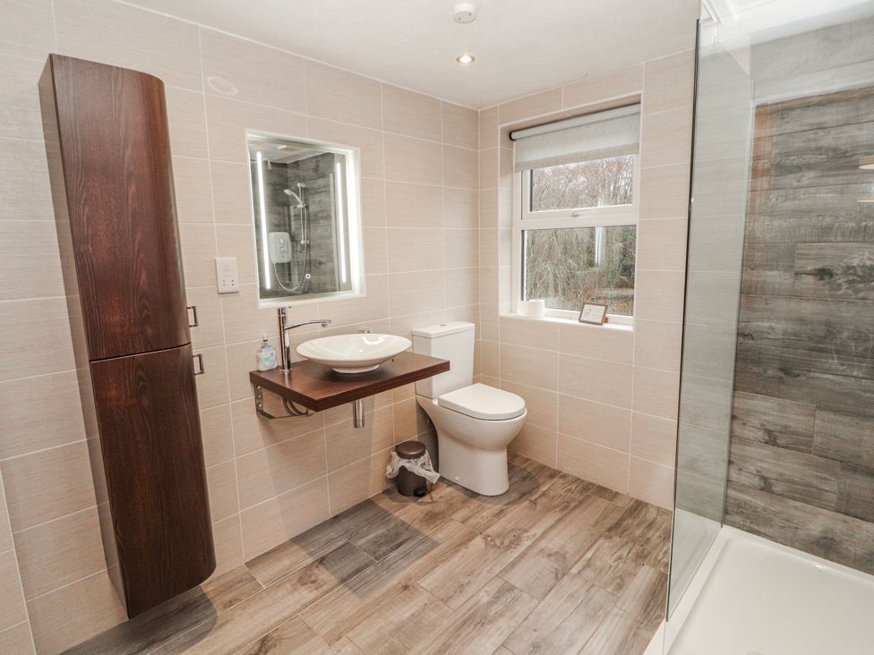 A bathroom with a sink, toilet, and shower at Greenbank Cottage in Winster near Bowness-On-Windermere