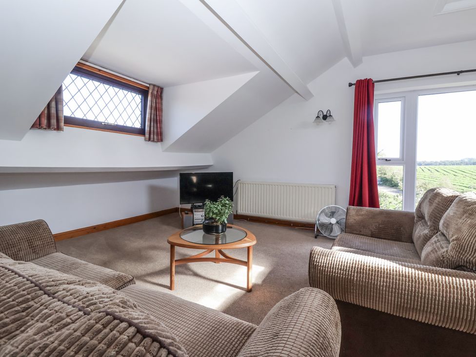 A sitting room with a television and sofa at East Cottage near Rillington