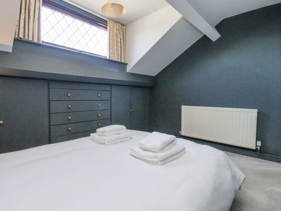 A bedroom with a bed and towels on top in East Cottage near Rillington