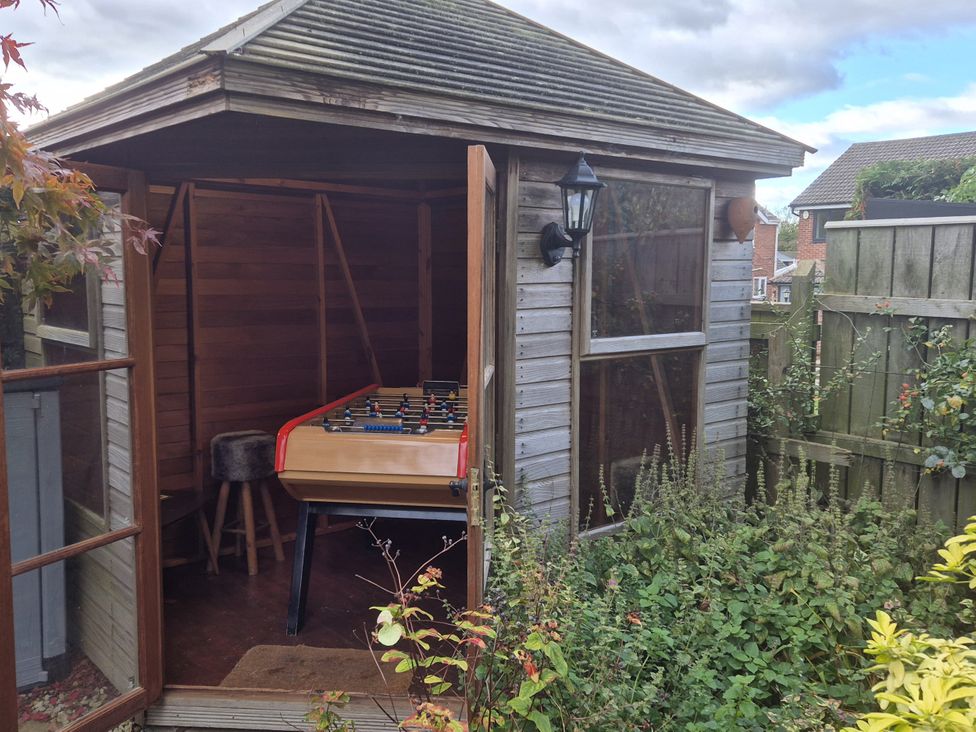 A garden shed with a foosball table and a stool at Clover Leaf in Guisborough