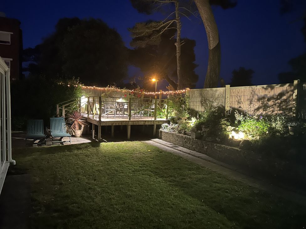 A garden with a deck and furniture at Hoppapill House in Bournemouth