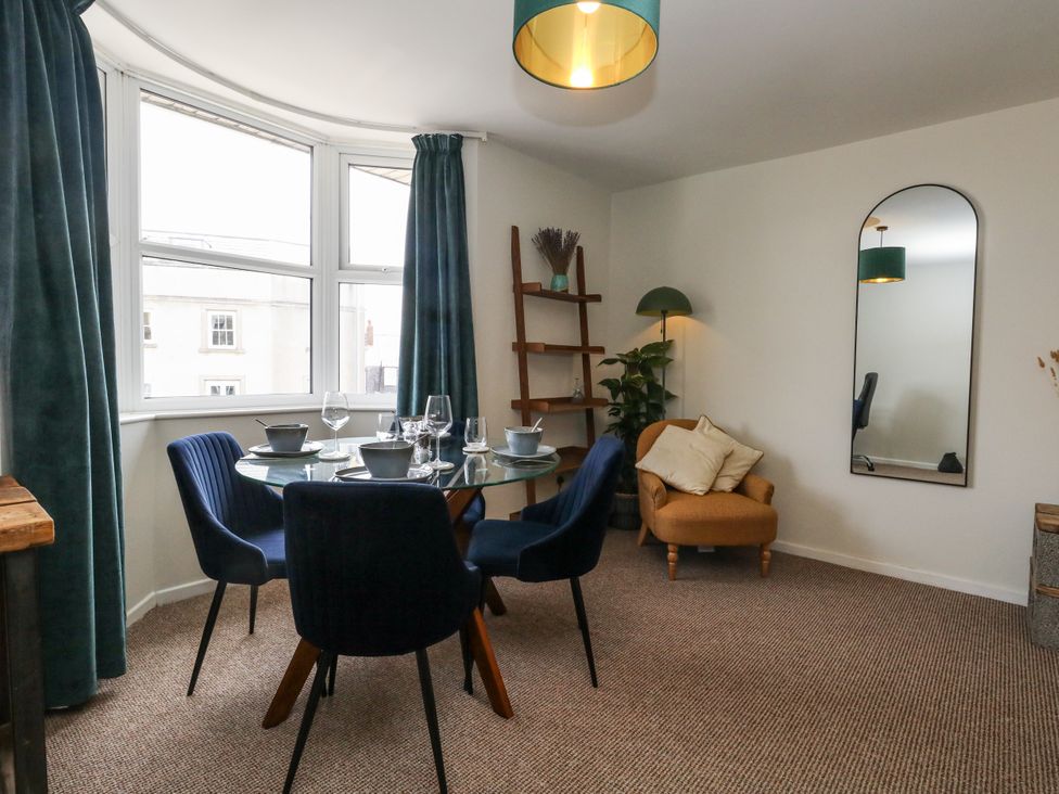 A dining room with a table and chairs at Beachcomb in Weymouth