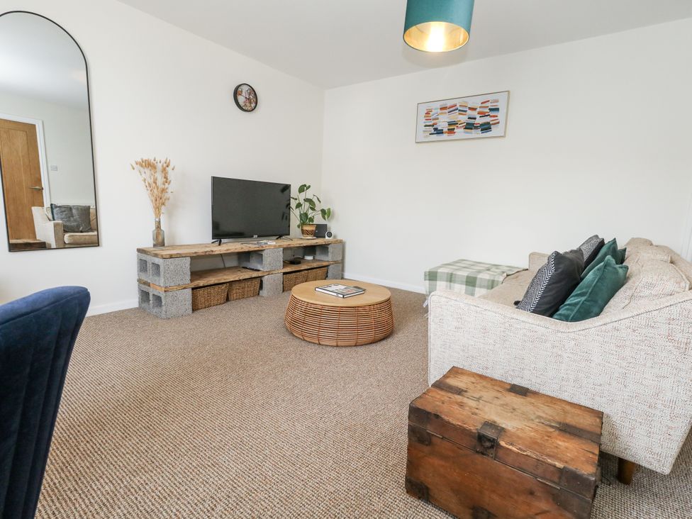 A living room with a television and sofa at Beachcomb in Weymouth