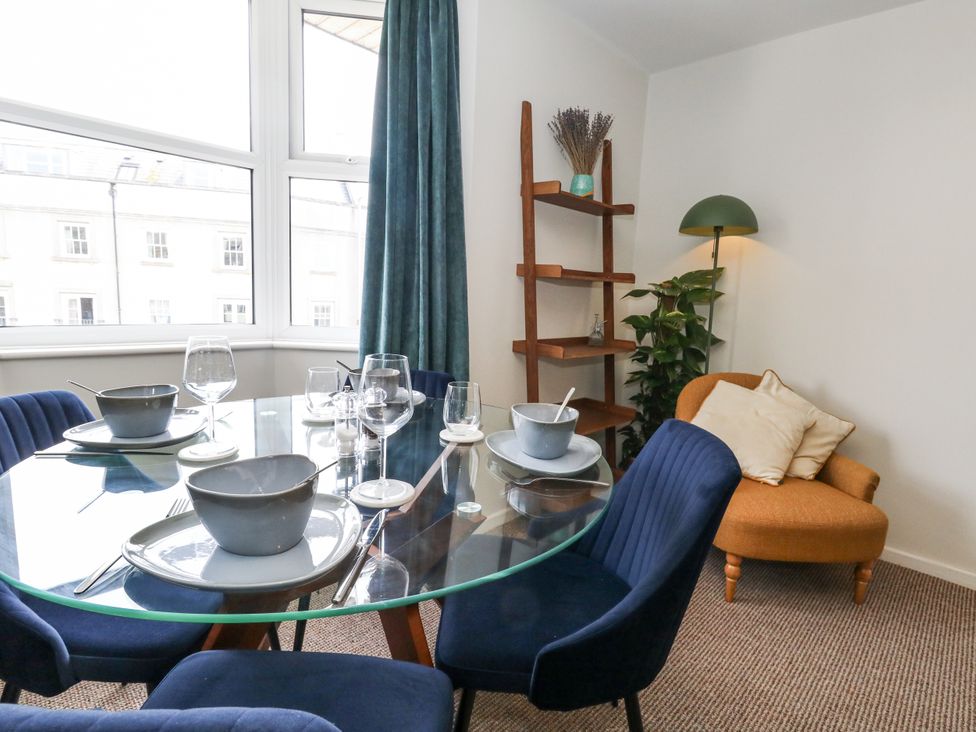 A dining room with a table set for meals at Beachcomb in Weymouth