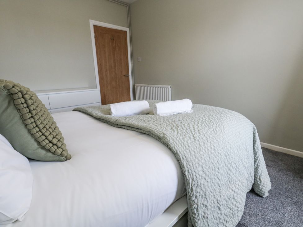 A bedroom with a bed and towels at Beachcomb in Weymouth