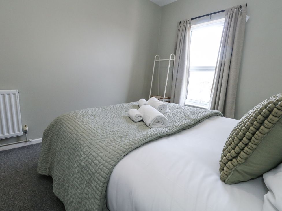 A bedroom with a bed and towels on it at Beachcomb in Weymouth
