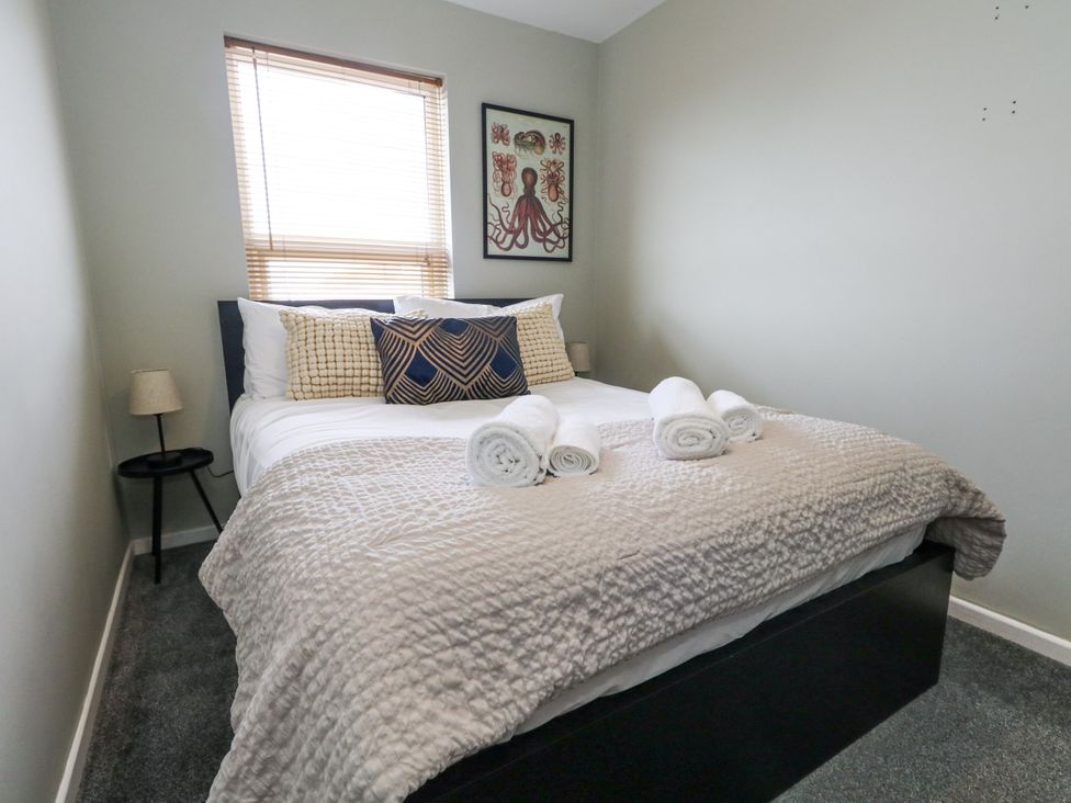 A bedroom with a bed and towels at Beachcomb in Weymouth