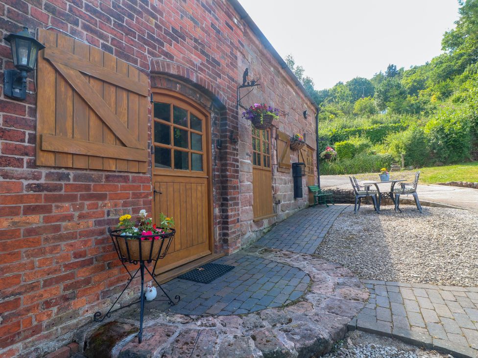 An outdoor area with a door and seating at Bluebell Barn in Stoke-on-Trent