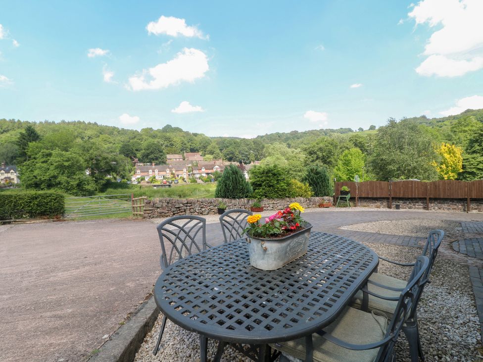 An outdoor area with a table and chairs overlooking a landscape at Bluebell Barn Stoke-on-Trent