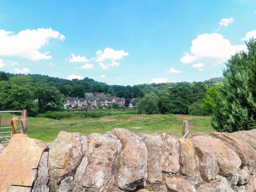 A landscape view with a stone wall and houses in the background at Bluebell Barn Stoke-on-Trent