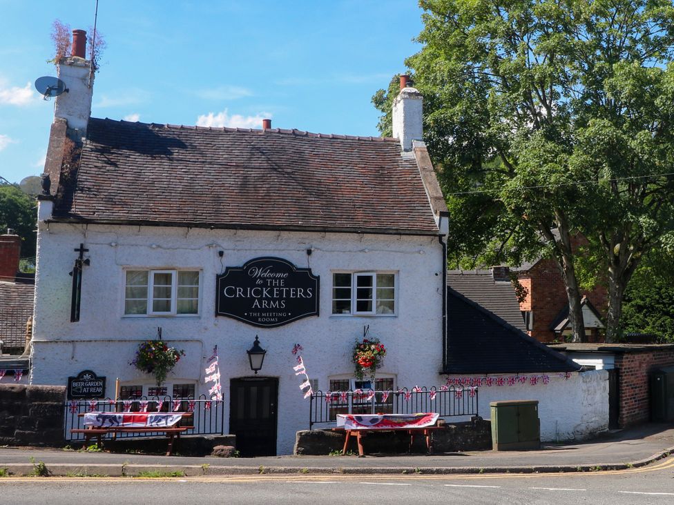 A pub with a sign and benches at The Cricketers Arms Stoke-on-Trent