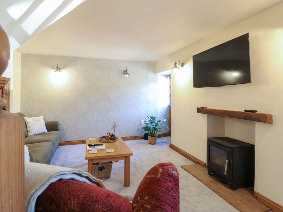 A living room with a sofa and coffee table at Bluebell Barn in Oakamoor