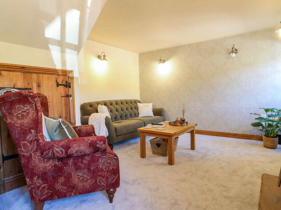 A living room with a sofa and armchair at Bluebell Barn in Oakamoor