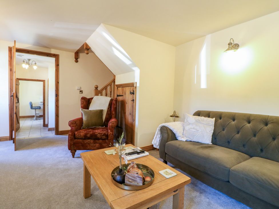 A living room with a sofa and armchair at Bluebell Barn in Oakamoor