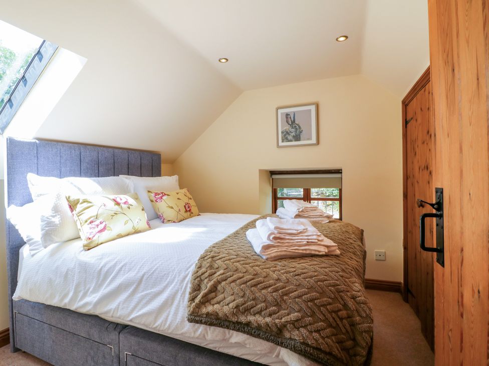 A bedroom with a bed and towels at Bluebell Barn in Oakamoor
