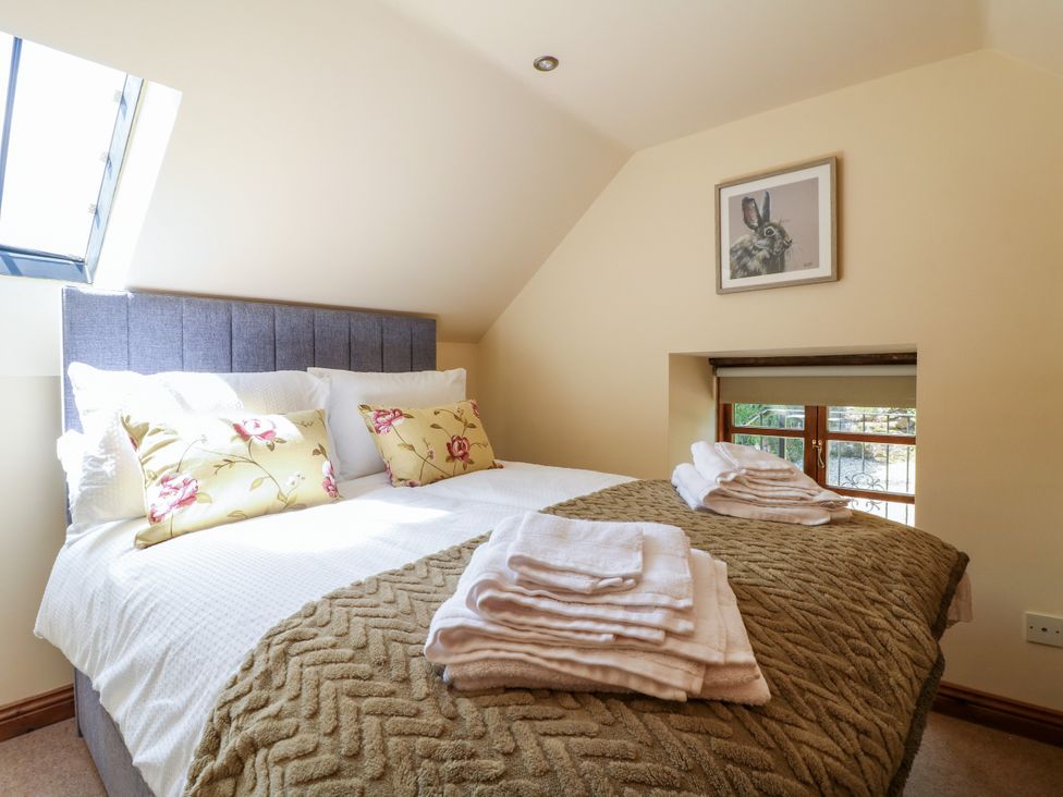 A bedroom with a bed and pillows at Bluebell Barn in Oakamoor