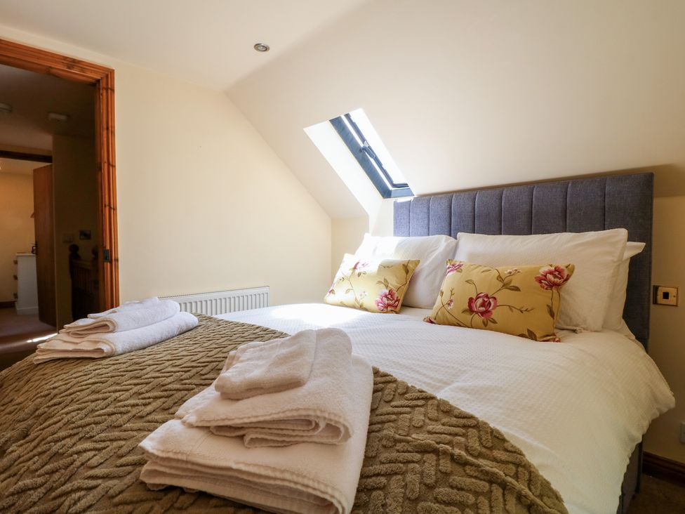 A bedroom with a bed and pillows at Bluebell Barn in Oakamoor