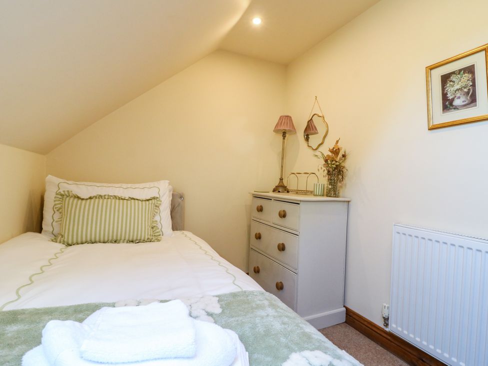 A bedroom with a bed and dresser at Bluebell Barn in Oakamoor