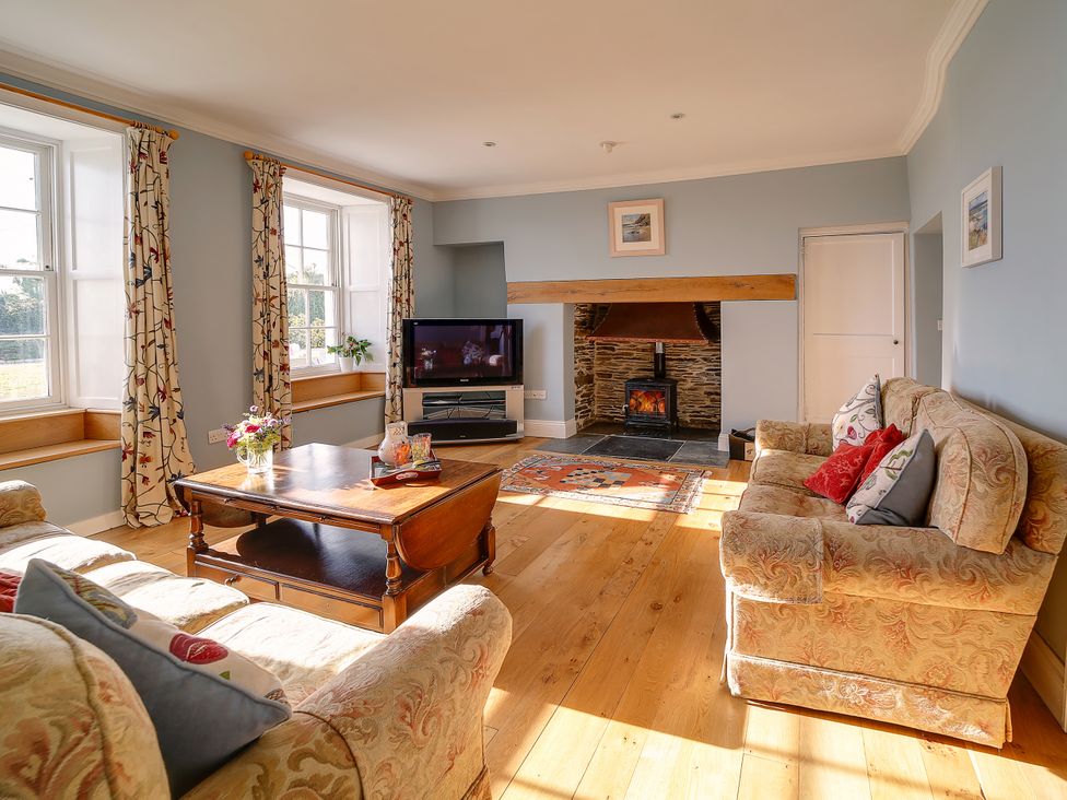 A living room with sofa and television at Porthcothan House in St Merryn