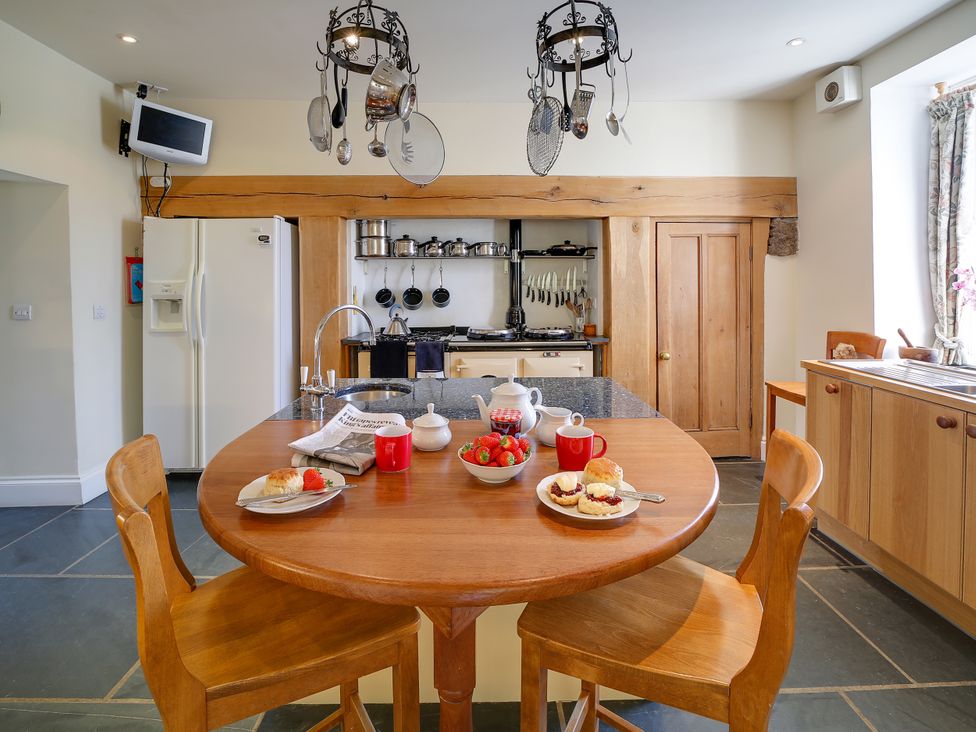 A kitchen with a round table and chairs at Porthcothan House St Merryn