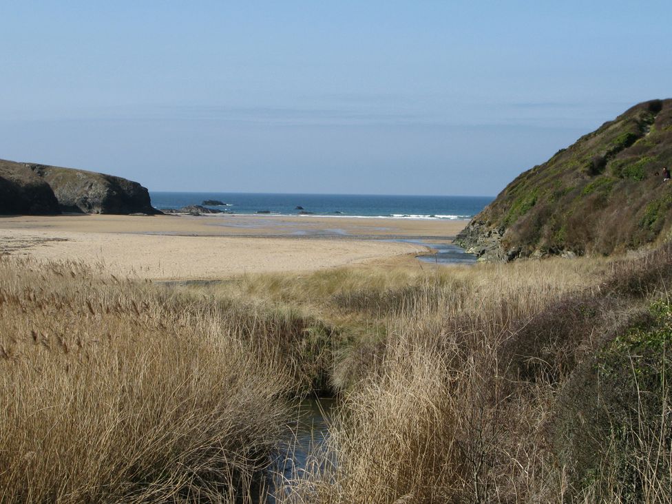 A beach view with sand and sea at Porthcothan House in Porthcothan