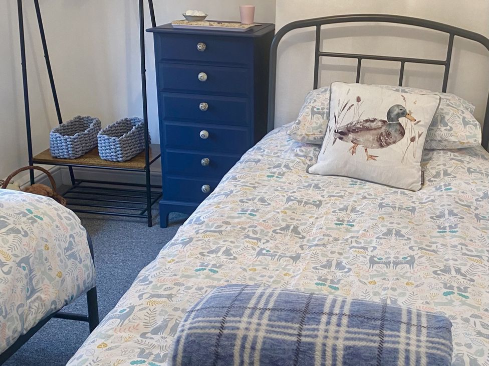 A bedroom with two beds and a dresser at Yoxall Cottage in Stoke-on-Trent
