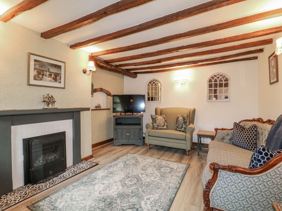 A living room with a fireplace and television at Yoxall Cottage in Stoke-on-Trent