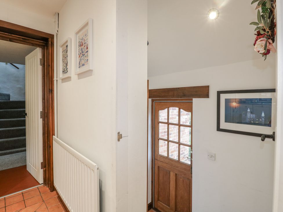 A hallway with a door and staircase at Yoxall Cottage in Stoke-on-Trent