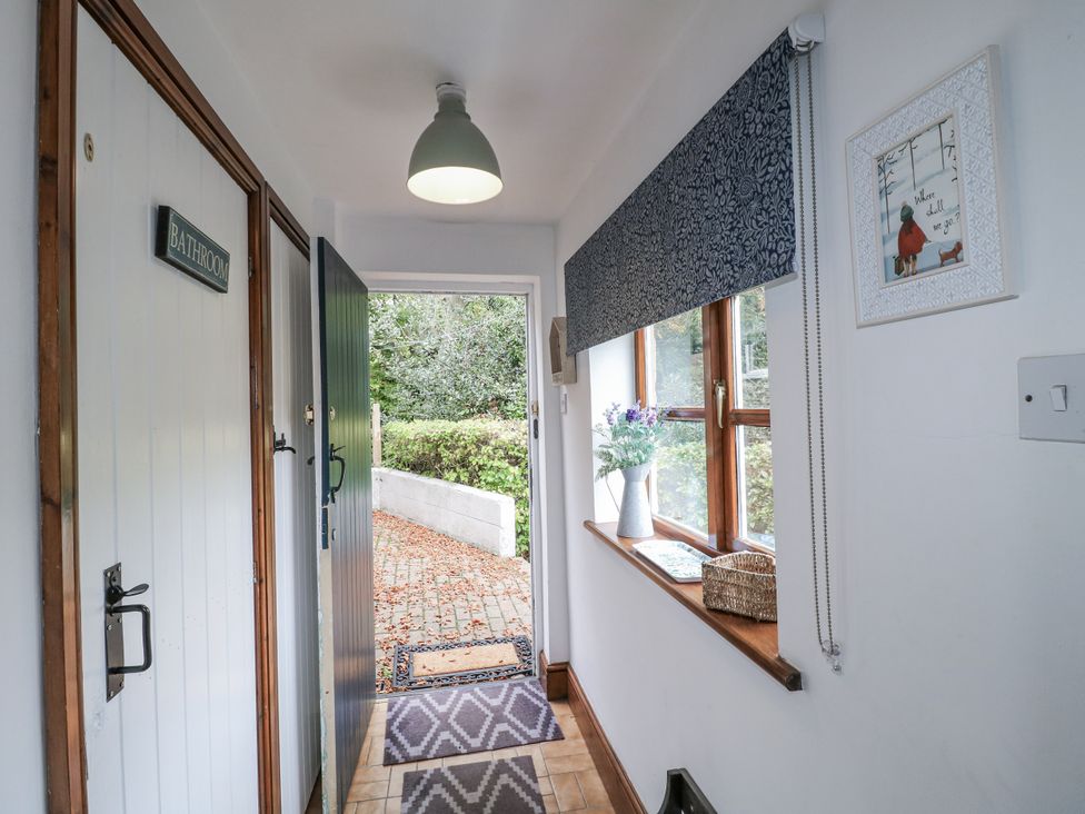 A hallway with a bathroom door and window at Yoxall Cottage Stoke-on-Trent