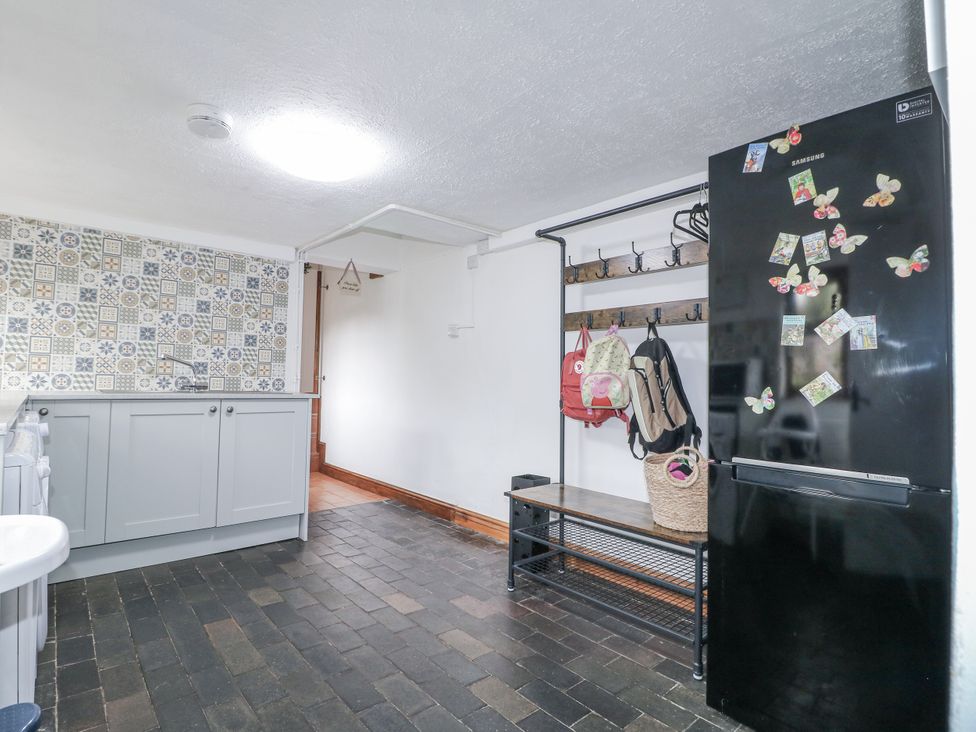 A kitchen with a refrigerator and kitchen cabinets at Yoxall Cottage in Stoke-on-Trent