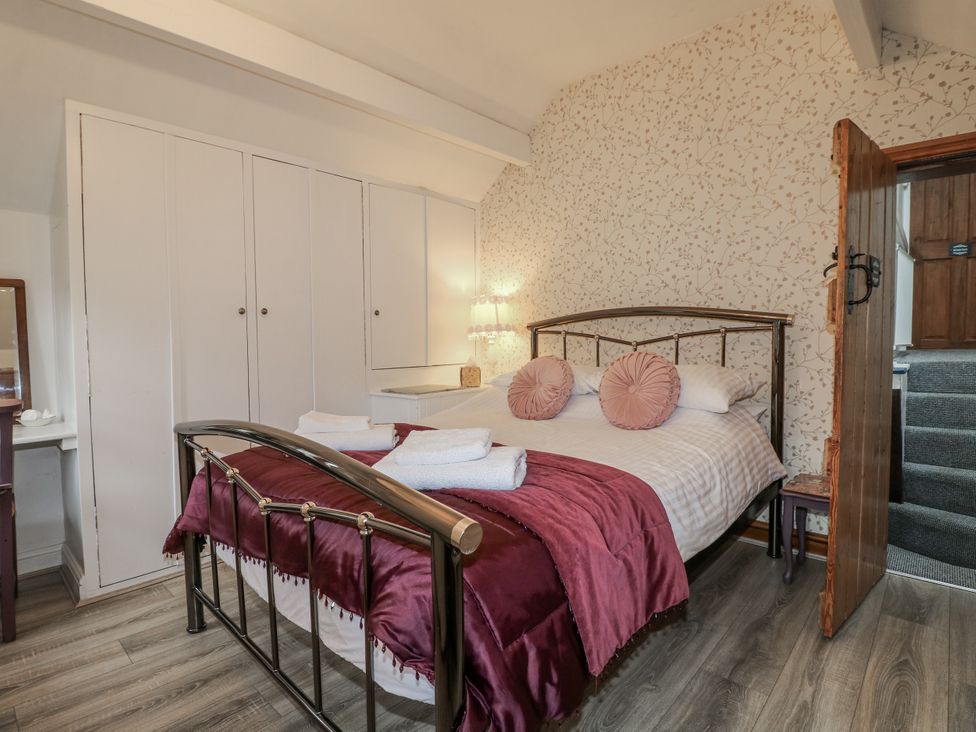 A bedroom with a bed and a wardrobe at Yoxall Cottage in Stoke-on-Trent
