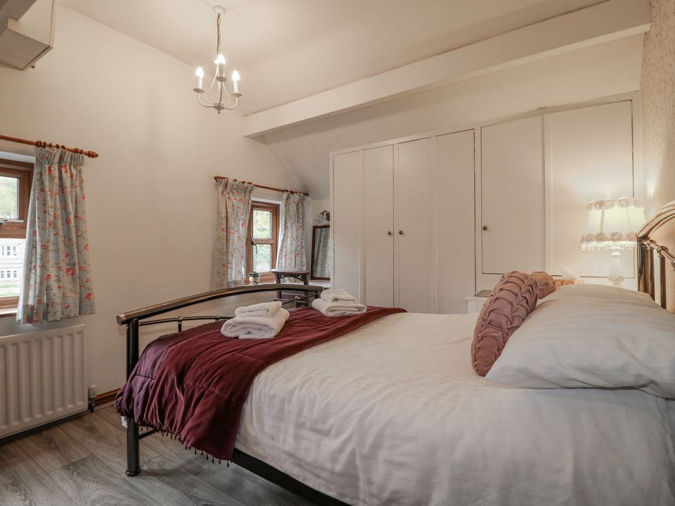 A bedroom with a bed and wardrobe at Yoxall Cottage in Stoke-on-Trent