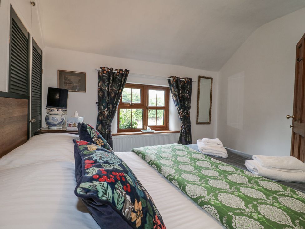 A bedroom with two beds and a window at Yoxall Cottage in Stoke-on-Trent