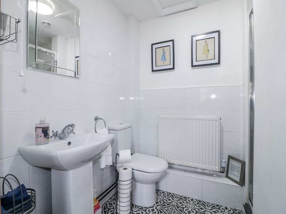 A bathroom with a sink, toilet and mirror at Yoxall Cottage Stoke-on-Trent