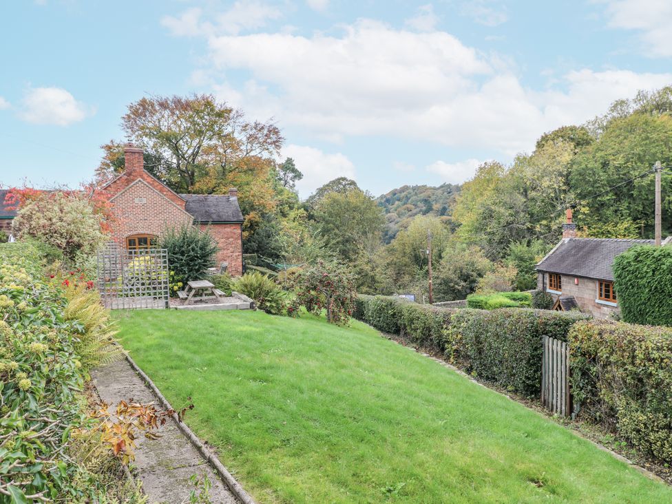 A garden with a house and trees at Yoxall Cottage Stoke-on-Trent
