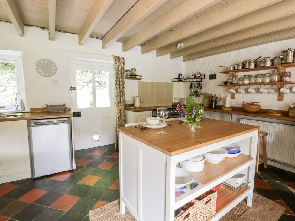 A kitchen with an island and shelves at Sycamore Vestry in Pontfaen near Fishguard