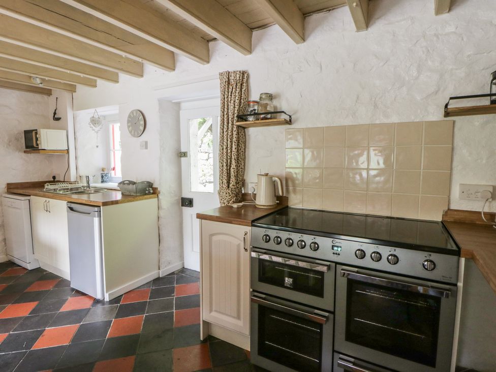 A kitchen with stove, sink, and microwave at Sycamore Vestry in Pontfaen near Fishguard